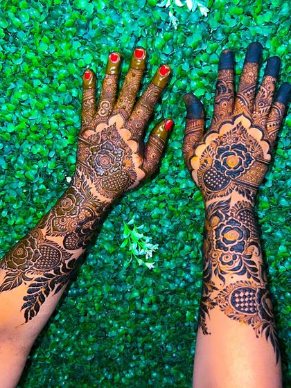 A playful pose showing off the bold and beautiful floral mehendi.