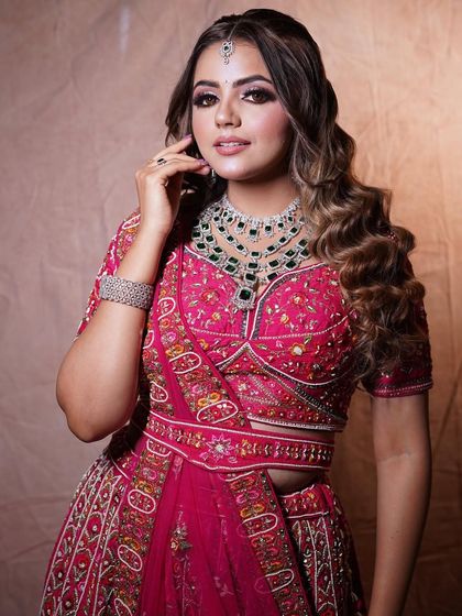 This bride looks absolutely stunning with her soft, glamorous waves. This open hairstyle is perfect for showcasing her beautiful jewelry and intricately embroidered lehenga.