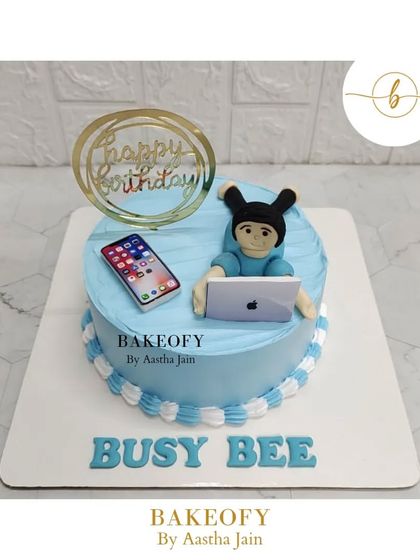 A workaholic-themed cake for a "busy bee." This lemon blueberry cake is topped with a fondant figure working on a laptop.