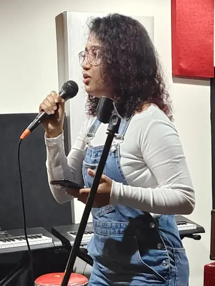 An action shot from an open mic night. Whether it's a big stage or a small room, I pour my heart into every performance. You can see me here with my keyboard and mic, ready to share some music.