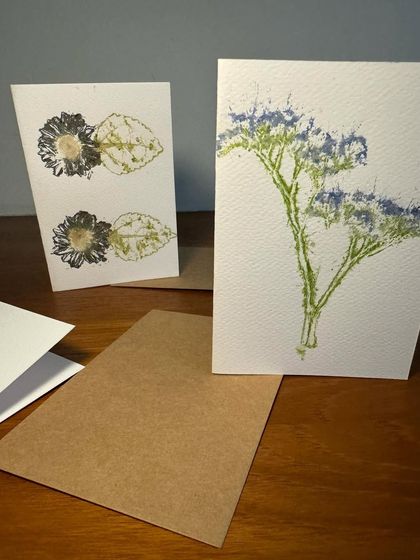 Two distinct card designs side-by-side. One features a bold, symmetrical flower print, while the other has a more delicate, branching floral pattern, showing the versatility of the craft.