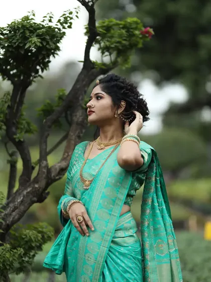 A beautiful portrait of a client in a traditional Nauvari saree. The makeup and braided updo are designed to complement the royal feel of this Maharashtrian attire.