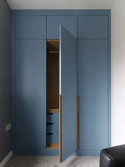 This view shows one door open, revealing the hanging rail and internal drawers, demonstrating the practical storage solutions we build.