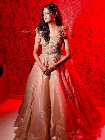 The bride posing in her stunning reception gown. The soft curls and glowing makeup create a look that is both modern and timelessly beautiful.