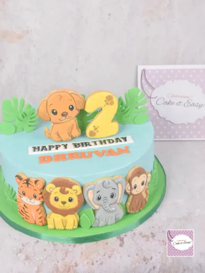 The finished jungle animal cake for Dhruvan's second birthday. The animals are all hand-decorated cookies, placed around a smooth buttercream cake.