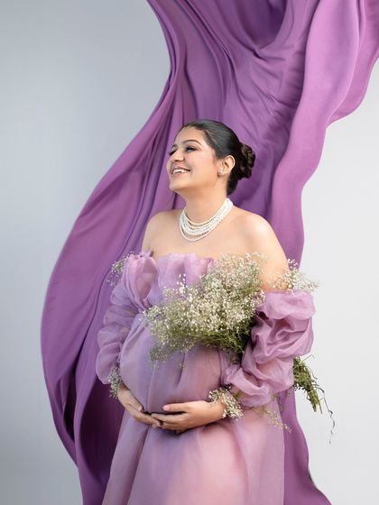 The joy of blossoming. This shot captures a beautiful, happy expression, with the flowing fabric and bouquet of baby's breath adding to the overall dreamy and romantic feel.