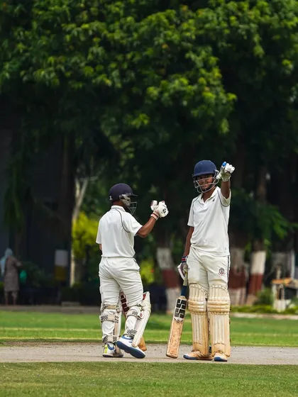 A moment of celebration between two batsmen after a successful partnership. I encourage my players to acknowledge each other's contributions and play as a cohesive unit.
