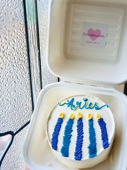 An Aries-themed bento cake with blue ombre candles. We can create custom designs for any zodiac sign to celebrate your season.