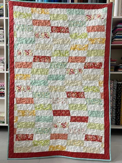 A hand-pieced baby quilt with a simple, colorful block design.