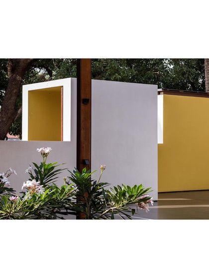 The play of solid and void, color and texture, is a key theme in the museum's design. Here, a white wall with a yellow-lined opening frames a view of the garden.