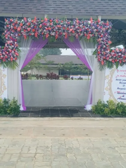 A great event starts with a great entrance. Here, I designed a wide floral arch with purple and white drapes, and included personalized welcome boards featuring the couple's photo and a message for their guests.