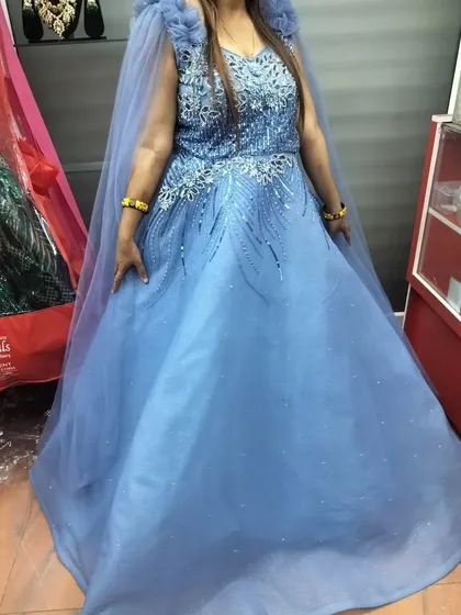 This gown is perfect for making an entrance. The cape adds drama, and the color is a beautiful, sophisticated shade of blue.
