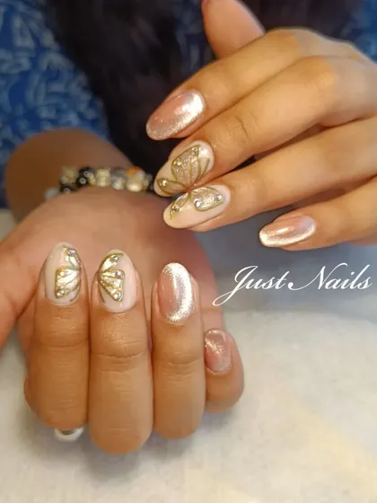 A delicate and whimsical design featuring a shimmery nude base with hand-painted gold butterfly wings and rhinestone accents.