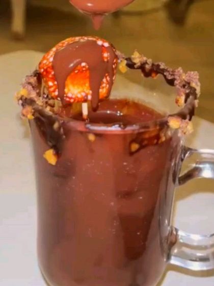 This is our signature hot chocolate, with a chocolate-dipped strawberry and a chocolate-rimmed glass. It's an indulgent drink that's also a dessert.