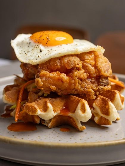 The irresistible stack of crispy fried chicken and fluffy waffles, a signature savory dish on our Sunday brunch menu.