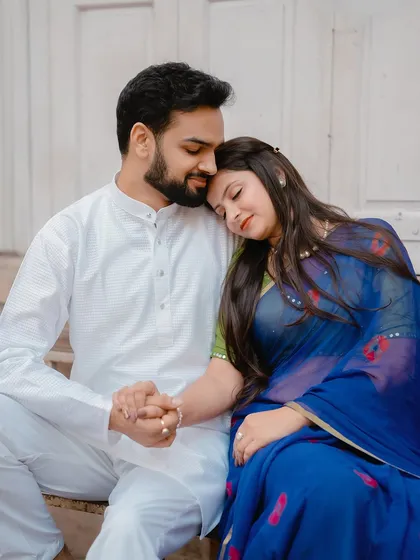 A tender and peaceful moment, with the bride resting her head on the groom's shoulder, captured on the steps of a traditional building.