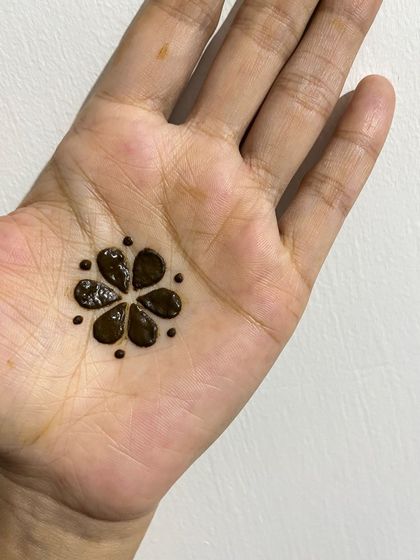 A very simple and sweet design featuring a single six-petaled flower in the center of the palm.