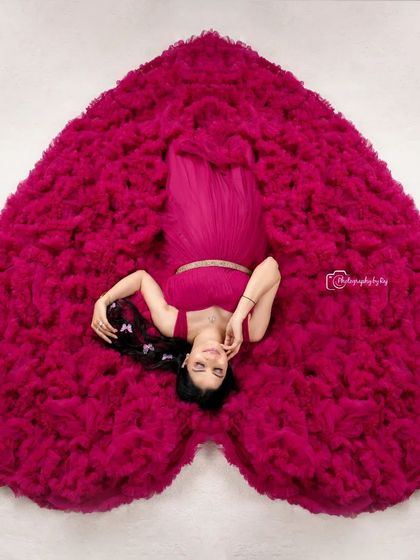 Our signature overhead "sleeping pose" in a vibrant pink ruffled gown, arranged to form a heart.