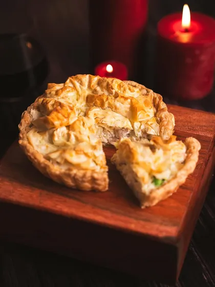 A slice of our Chicken and Leek Pot Pie, featuring a flaky, golden crust and a creamy, hearty filling. It's the ultimate comfort food, especially during the holidays.