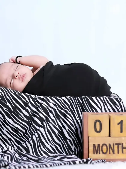 A clean and simple setup for a one-month-old baby, swaddled and resting peacefully. The focus remains entirely on the baby's serene presence.