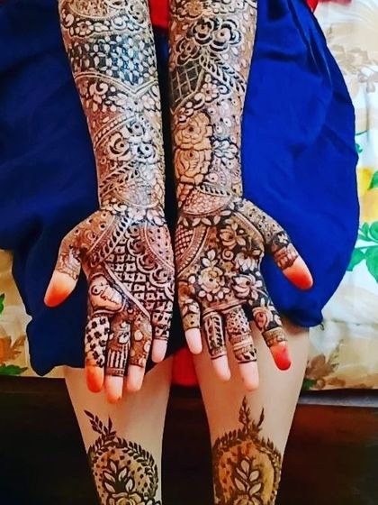 A beautiful example of full bridal henna with matching designs on the feet. The arm design is rich with florals and paisleys, while the feet feature a simpler, elegant pattern.
