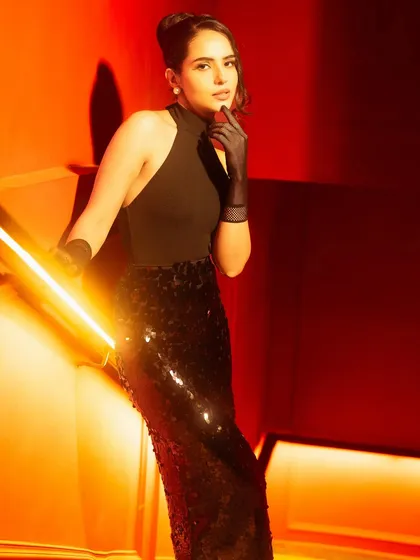 This shot is a study in using warm tungsten tones and a low key light to create drama. I teach how to use camera angles and sculpted light to elongate the frame and enhance textures like the sequins on the skirt.