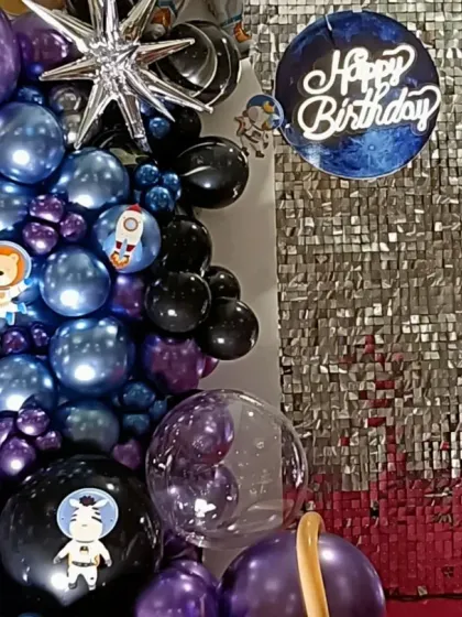 A detailed look at the galaxy balloon arrangement, featuring metallic purple and blue balloons, starburst foils, and planet-themed accents.