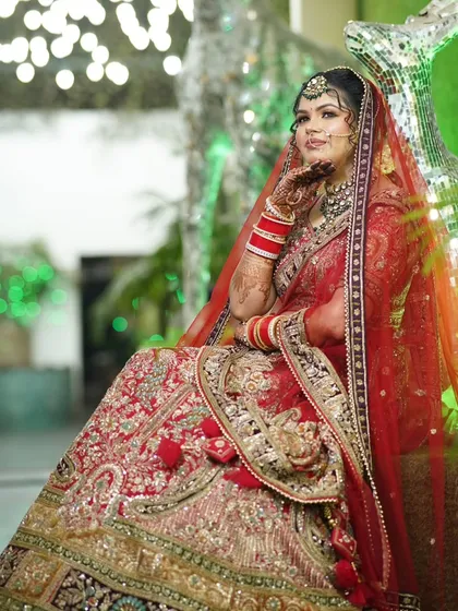 A full-body shot of the bride seated elegantly, with her hand on her chin. The composition is both regal and modern.