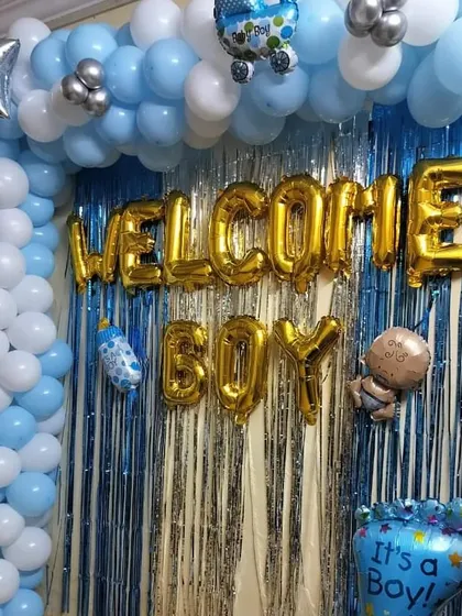 This is my classic "Welcome Boy" decoration, perfect for celebrating the arrival of a baby boy. The design includes a blue, white, and silver balloon arch complemented by a silver tinsel backdrop and cute baby-themed foil balloons.