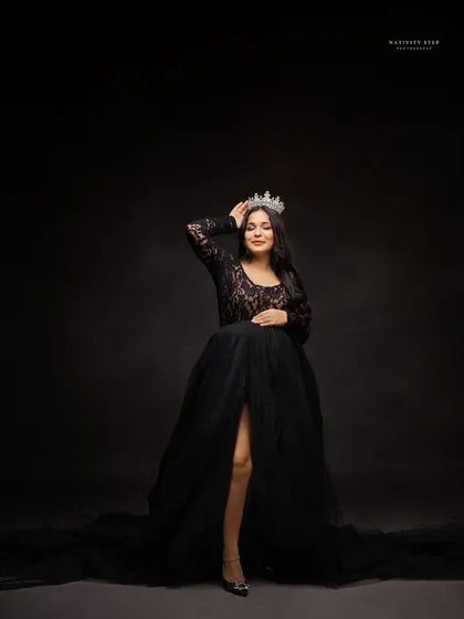 A regal solo portrait of the mother-to-be, confidently wearing her crown and a beautiful black lace gown.