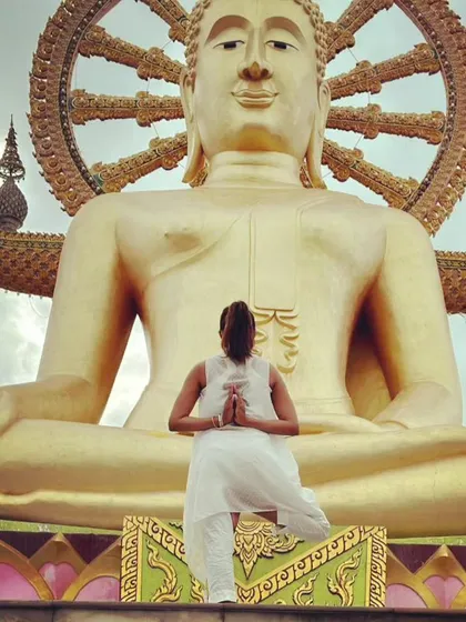 Practicing a balancing pose in front of the Big Buddha in Thailand. To conquer oneself is a greater task than conquering others, and yoga is a powerful tool for that inner work.