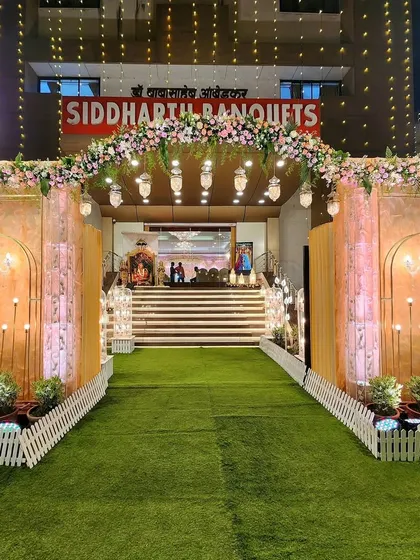 A grand entrance for a pastel-themed reception at Siddharth Banquets. The design features ornate panels, chandeliers, and floral arches, creating a look of timeless elegance.
