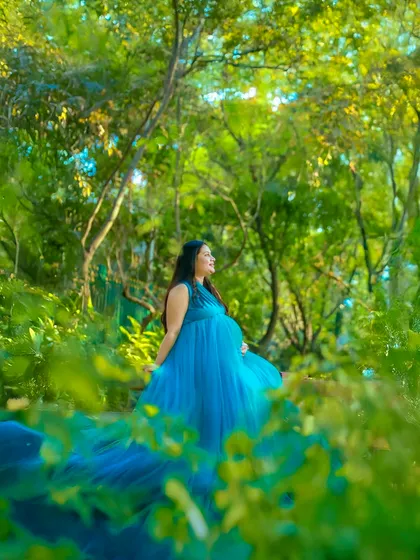 A fairytale moment captured in the heart of nature. This mother-to-be looks serene and beautiful in a flowing blue gown, surrounded by the lush greenery of a Bangalore garden.