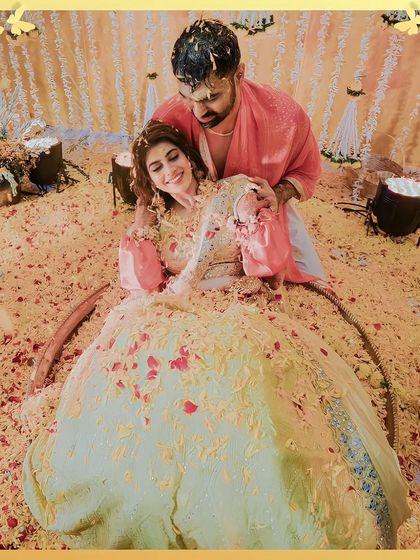 A romantic shot of the couple amidst a sea of flower petals during their 'phoolon ki holi' Haldi.