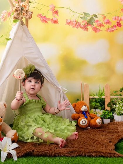 An autumn-themed fairytale, with this little girl sitting in a tent surrounded by flowers, teddy bears, and a warm, sunny glow.