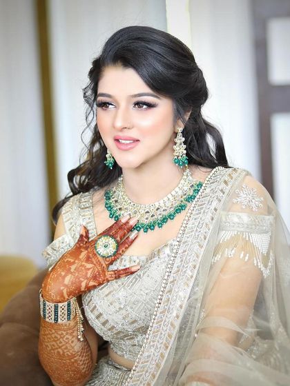 The client looks radiant and happy, her hair and makeup perfectly done for her special day.