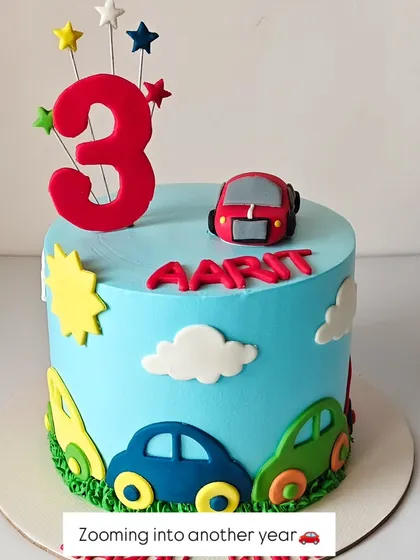 Zooming into another year! This cute and colorful cake is perfect for a toddler's birthday, featuring bright cars, clouds, and a big number "3" topper.