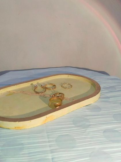 This is another trinket tray in a warm yellow marble finish. It's a versatile piece that can be used to hold jewelry, keys, or other small everyday items.