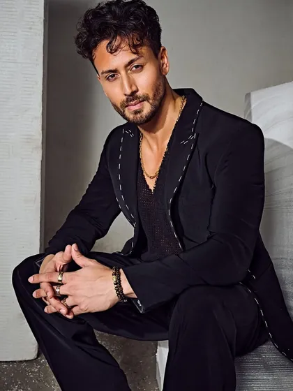 Tiger Shroff in a striking pose for a studio photoshoot. The Tisa Studio suit, paired with an Ayana Silver Jewellery neck chain, creates a look that is both sharp and contemporary.