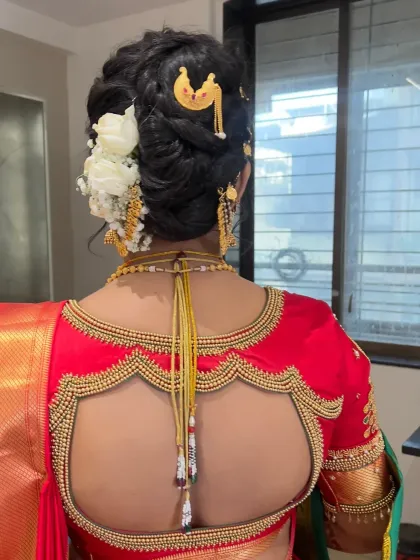 A detailed view of a classic bridal bun adorned with white flowers and traditional hair accessories.