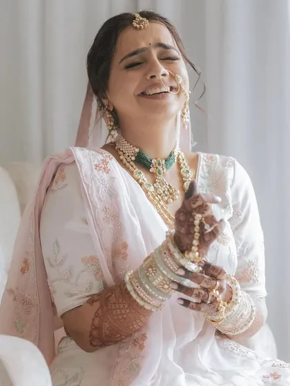 A candid shot of a bride with her messy, romantic updo. This style is perfect for a Phera ceremony, offering an elegant look that feels soft and natural.
