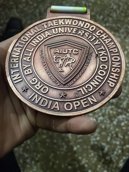 A close-up of the bronze medal from the 5th Open International Taekwondo Championship. A prestigious honor for any competitor.