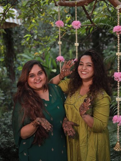 Two friends from the bride's squad sharing a happy moment and showing off their matching henna vibes.
