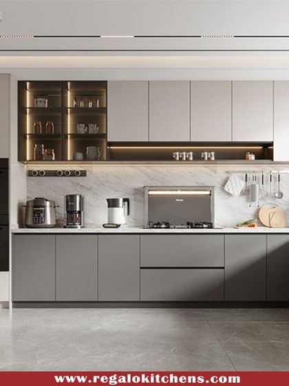 This kitchen showcases a modern layout with integrated double ovens and handle-less grey cabinets. The U-shaped design creates an efficient work triangle, while the marble backsplash adds a touch of timeless elegance.