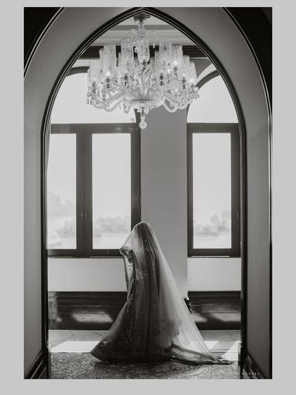 A silhouette of a bride, waiting. This black and white shot is all about mood and anticipation, using the grand architecture and natural light to create a timeless, artistic photograph.