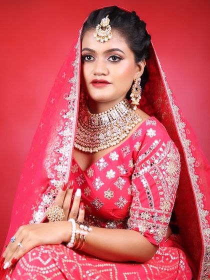 A classic bridal portrait pose, showing the beautiful dupatta setting and the radiant makeup.