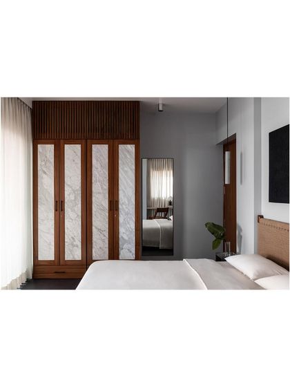 A full view of the marble-inlaid wardrobe I designed. The vertical grain of the marble adds a sense of height and drama to the room, while the wood frame provides warmth.