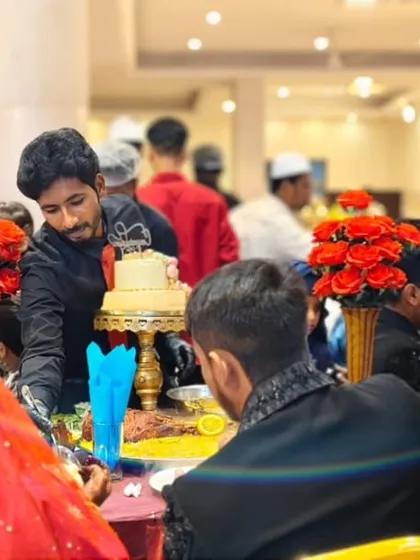 A candid moment at the Shahi Table, where our staff serves the wedding cake, adding a personal touch to the celebration.
