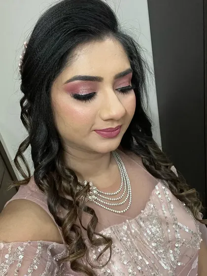 Another view of this stunning party look, showing how the hairstyle and makeup come together. The curls add texture and volume, balancing the dramatic eye makeup.