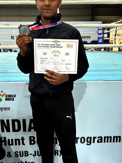 A young fighter from my academy holding his certificate of merit and medal from a national-level Khelo India event.